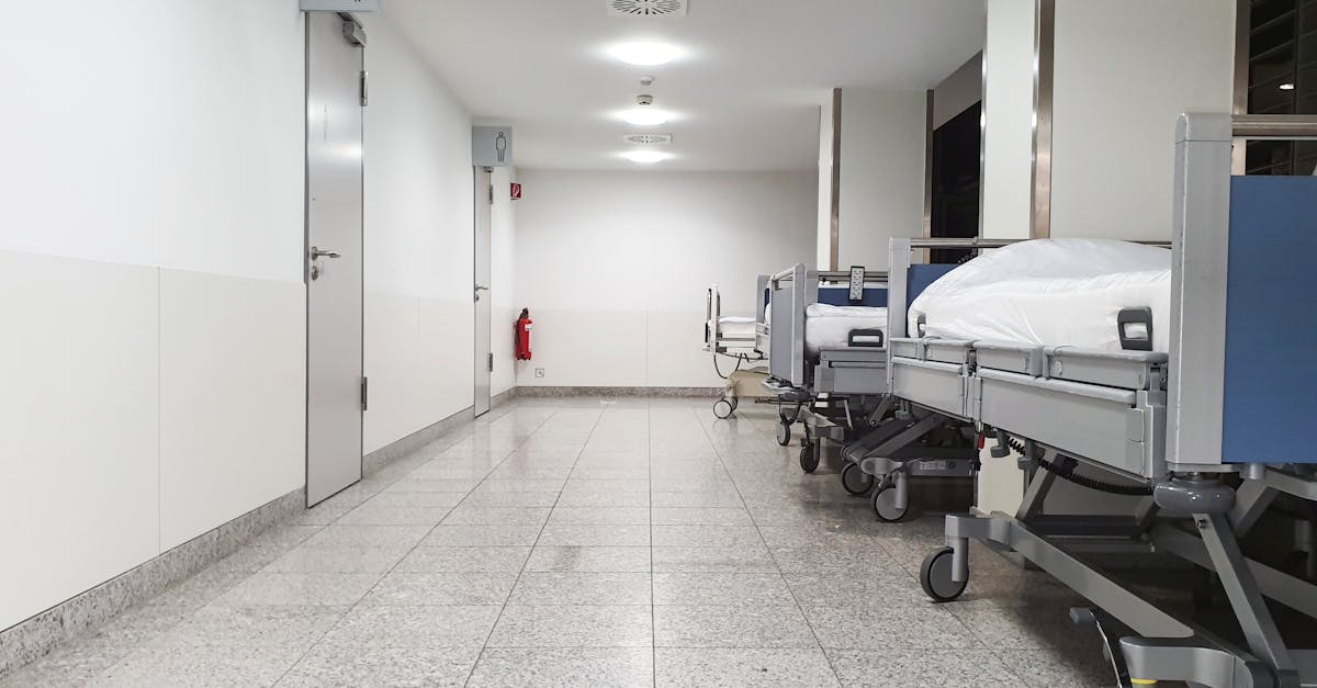 Modern hospital corridor with empty medical beds and sterile environment.