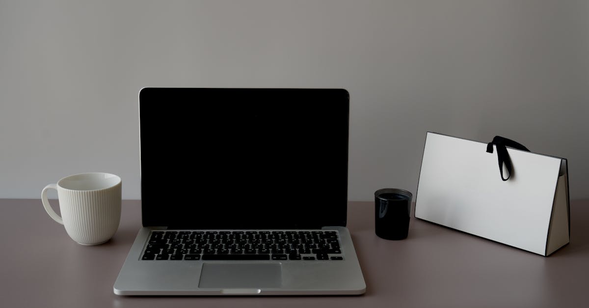 A sleek, minimalist workspace featuring a laptop, ceramic cup, and a stylish paper bag. Perfect for productivity.